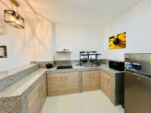 a kitchen with wooden cabinets and a stainless steel refrigerator at Departamento 2 Habitaciones con Balcón a 10min Consulado Americano in Guayaquil