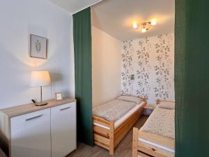 Cette petite chambre comprend deux lits et une lampe. dans l'établissement Apartment B 94 by Interhome, à Dittishausen