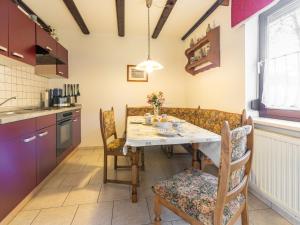 a kitchen and dining room with a table and chairs at Holiday Home Am Hohen Bogen-49 by Interhome in Arrach