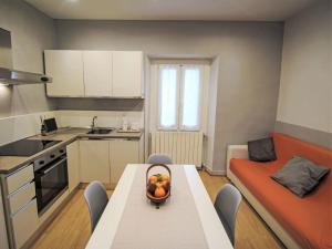 - une cuisine avec une table et un bol de fruits dans l'établissement Apartment Giardino del Bosso-1 by Interhome, à Germignaga