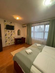 ein Schlafzimmer mit einem Bett mit zwei Handtüchern darauf in der Unterkunft Conacul de pe Lac in Şagu