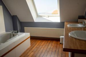a bathroom with two sinks and a tub and a window at villa port l epine, 4 chambres, vue mer in Trélévern