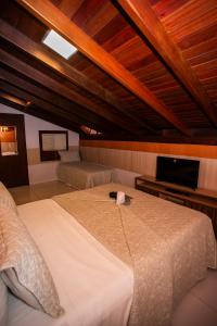 um quarto com uma cama grande e uma televisão em Casa Conceição em Fernando de Noronha