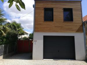 a house with a garage door in front of it at coin de paradis 3 chambres in Fouras