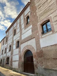 a brick building with a door and an archway at Casa Rural EL TORREÓN in Fontiveros