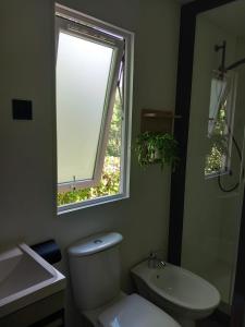 a bathroom with a toilet and a sink and a window at Camping Villaggio Il Collaccio in Preci