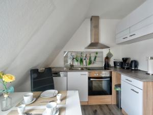a kitchen with white appliances and a table at Apartment Born 3 by Interhome in Schieder-Schwalenberg