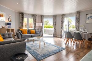 una sala de estar con un sofá y una mesa en Windrush Lake 41, Kingfisher House, en South Cerney