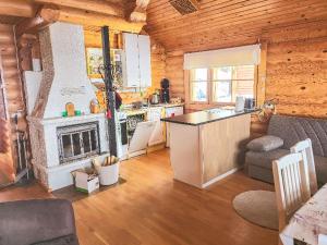 eine Küche mit einem Kamin in einem Blockhaus in der Unterkunft Holiday Home Alppi 7a paritalo by Interhome in Hyrynsalmi