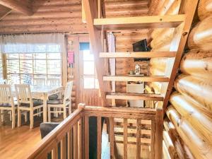 eine Treppe in einem Blockhaus mit einem Esszimmer in der Unterkunft Holiday Home Alppi 7a paritalo by Interhome in Hyrynsalmi