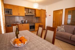 Charm Apartment T2 All With Big Terrace Albufeira Self check-in في ألبوفيرا: مطبخ مع طاولة مع وعاء من البرتقال عليه