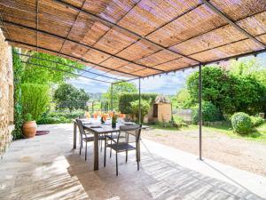 un patio con mesa y sillas bajo una pérgola en Holiday Home La Ferme by Interhome en Besse-sur-Issole