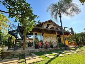 uma casa com uma escada e uma palmeira em Rancho Flor de Iris - Lago Corumbá IV em Alexânia