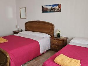 a bedroom with two beds with pink and white sheets at Venice Dream in Mestre