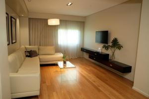 a living room with a white couch and a tv at Hotel Metropolitano Supara in Buenos Aires