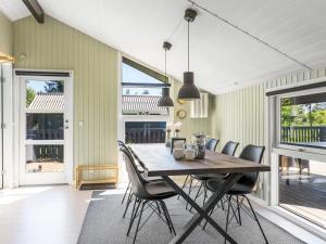 a dining room with a wooden table and chairs at Holiday Home Bryti - 500m from the sea in NE Jutland by Interhome in Hals