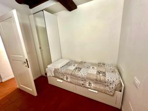ein kleines Schlafzimmer mit einem Bett und einem Spiegel in der Unterkunft Home 28 appartamento nel cuore di Modena centro in Modena