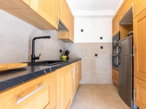 a kitchen with wooden cabinets and a stainless steel refrigerator at Holiday Home Cibada by Interhome in Pobla de Montornés