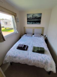 a bedroom with a bed with two towels on it at G & M Static Caravan Edinburgh in Port Seton