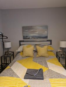 um quarto com uma cama grande e um cobertor amarelo em Caversham Lodge em Reading