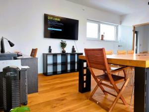 a living room with a table and a television on the wall at Apartmán Business Comfort se zahradou in Hradec Králové