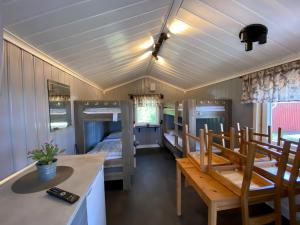 Zimmer mit Etagenbetten sowie einem Tisch und Stühlen in der Unterkunft Hyltena Stugby in Jönköping