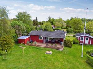 eine Luftansicht eines roten Hauses mit einem Hof in der Unterkunft Holiday Home Oskari - 175m from the sea in Sealand by Interhome in Slagelse