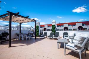 a patio with chairs and tables on a roof at Charm Apartment T2 All With Big Terrace Albufeira Self check-in in Albufeira