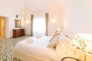 a bedroom with a large white bed and a dresser at Cerasella B&B in Ischia