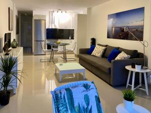 普拉亞戴爾雷安格萊斯的住宿－Tanife 310 - Playa del Ingles comfort Suite with Sunset view，客厅配有沙发和桌子