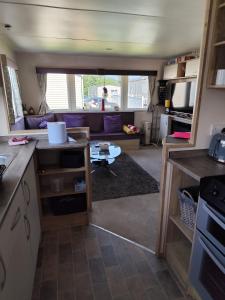 cocina y sala de estar con sofá y mesa en G & M Static Caravan Edinburgh en Port Seton