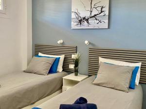 Tanife 310 - Playa del Ingles comfort Suite with Sunset view في بلايا ديل إنغلز: سريرين يجلسون بجانب بعض في غرفة النوم