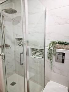 um chuveiro com uma porta de vidro na casa de banho em Carlos Place em Vila Franca de Xira