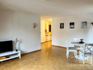 a living room with a table and a television at Golden Corner Oldtown Luzern in Luzern