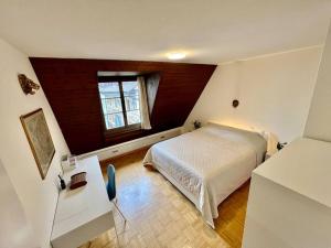 a bedroom with a white bed and a window at Golden Corner Oldtown Luzern in Luzern