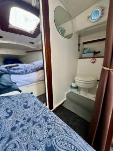 Habitación pequeña con cama y aseo en Vive la experiencia de dormir acunado por las olas cerca de Barcelona en Castelldefels