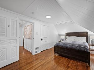 a bedroom with a bed and white walls and wood floors at Shadyside, Central 3C Spacious & Modern Private Bedroom With Shared Bathroom and Free Parking in Pittsburgh