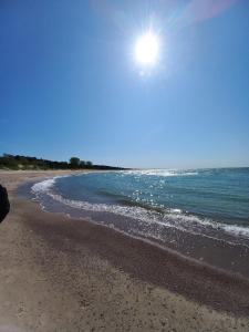 a view of a beach with the sun in the sky at ARKA 1 domki na wodzie w Mielnie, rower wodny, bezpłatny WIFI, Parking in Mielno