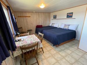 a bedroom with a bed and a table in a room at Chalets Bernatchez in Mont-saint-pierre