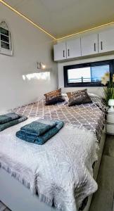 a bedroom with a large bed with pillows on it at ARKA 1 domki na wodzie w Mielnie, rower wodny, bezpłatny WIFI, Parking in Mielno