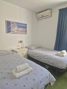 2 camas en una habitación de hospital con cortinas azules en Villa Alhambra, en Nerja