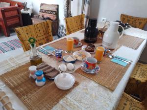 a table with breakfast food and orange juice on it at Djerba rêve vacances Zohra in Midoun