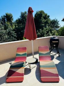 twee stoelen en een tafel en een parasol op een patio bij JUST RENOVATED stylish 2 bedrooms apartment only a few steps from the beach! in Novigrad Istria