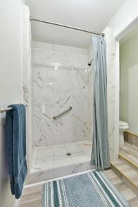 a bathroom with a marble shower with a blue towel at Bedroom and bathroom - perfect for solo traveler in Wellington