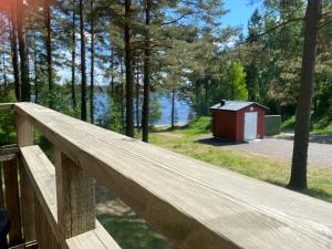 uma cerca de madeira com um pequeno barracão ao fundo em Hyltena Stugby em Jönköping