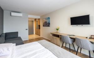 a room with a bed and a desk with a tv at Pokoje Salsa in Dąbki