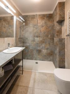 a bathroom with a sink and a tub and a toilet at Pokoje Salsa in Dąbki +21 photos