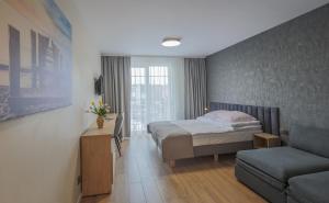 a hotel room with a bed and a couch at Pokoje Salsa in Dąbki