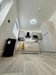 an attic kitchen with white cabinets and a wooden floor at Cozy Haven Your Perfect 1Bed LE2 in Leicester +6 photos