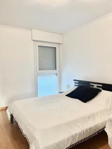 a bedroom with a large white bed with a window at M037 Marquer Joli T2 in Ambilly